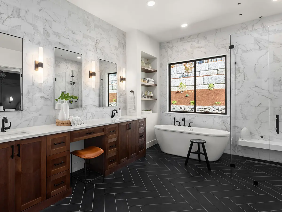 A bathroom renovation with black porcelain tile and a large wood double vanity