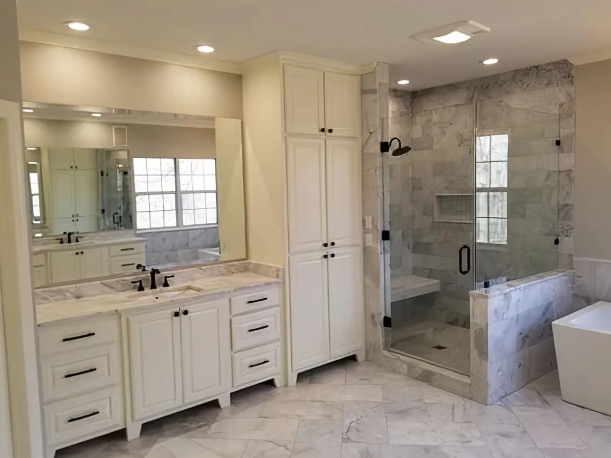 A bathroom with white tile flooring, cabinets, vanity, and freestanding tub