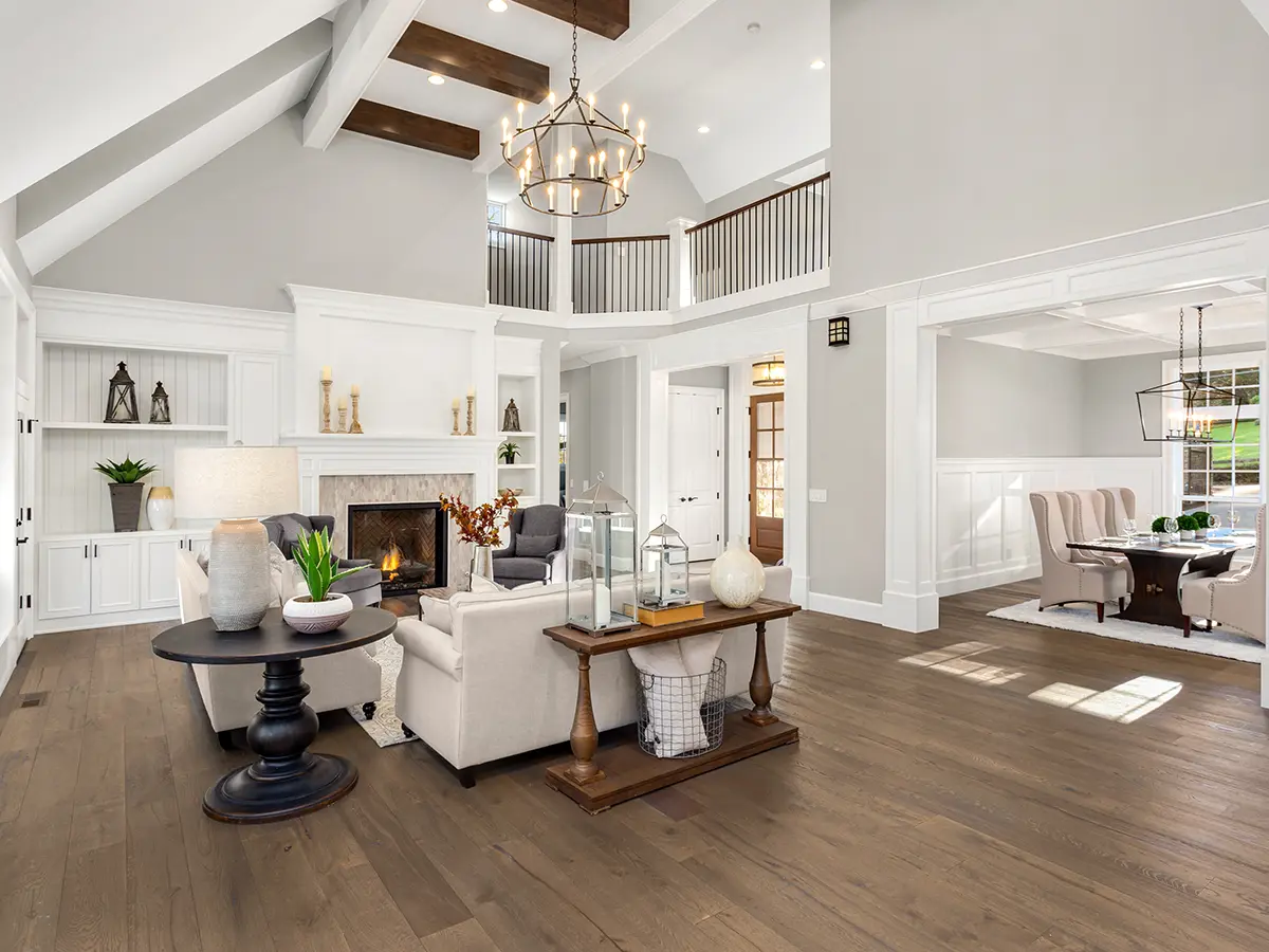 A large living space with LVP flooring and a white couch in front of a fireplace