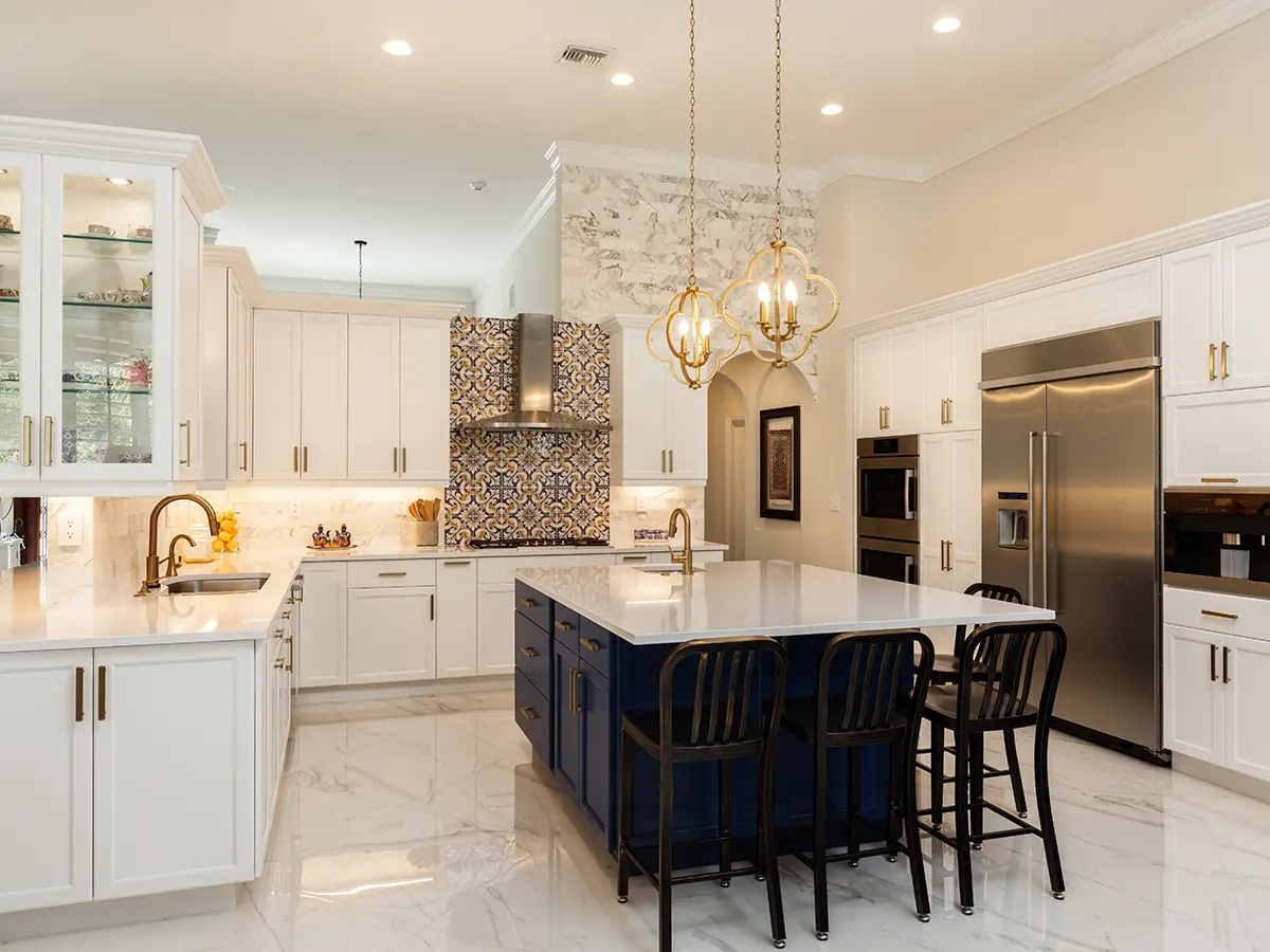 A large open-space kitchen with a navy blue island and white kitchen cabinets