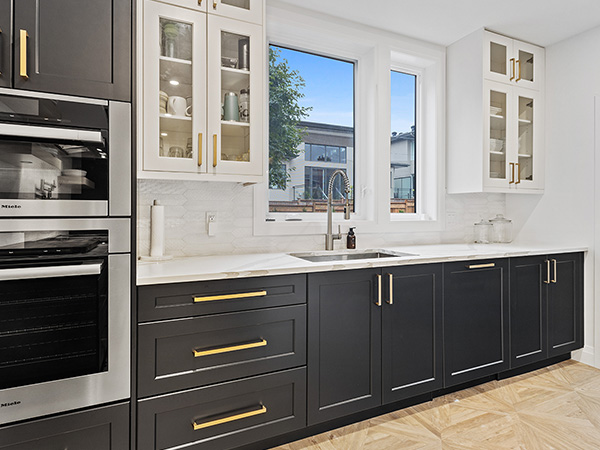 Beautiful black and white kitchen cabinets with golden hardware