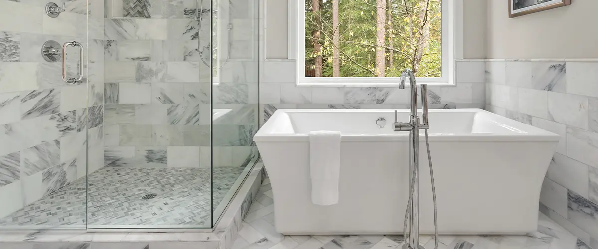 A tub and glass walk-in shower in a bathroom with tile floor and walls