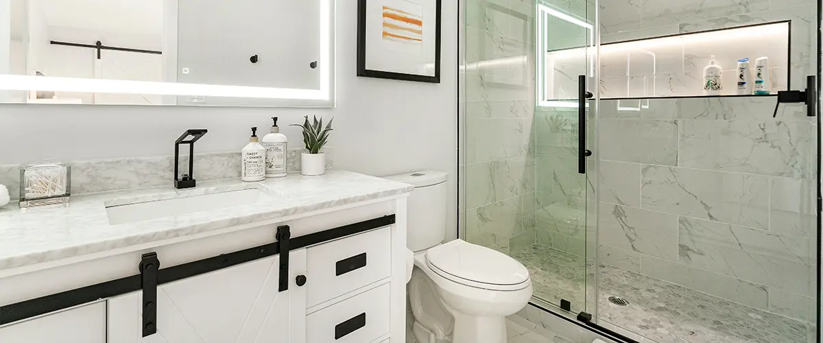 Modern white vanity with sliding door and glass walk-in shower
